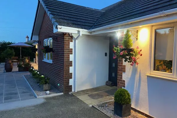 Night time view showing outside lighting and patio